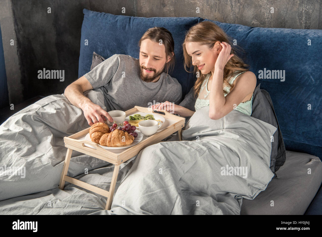 Glückliches junges Paar hat das Frühstück im Bett Stockfoto