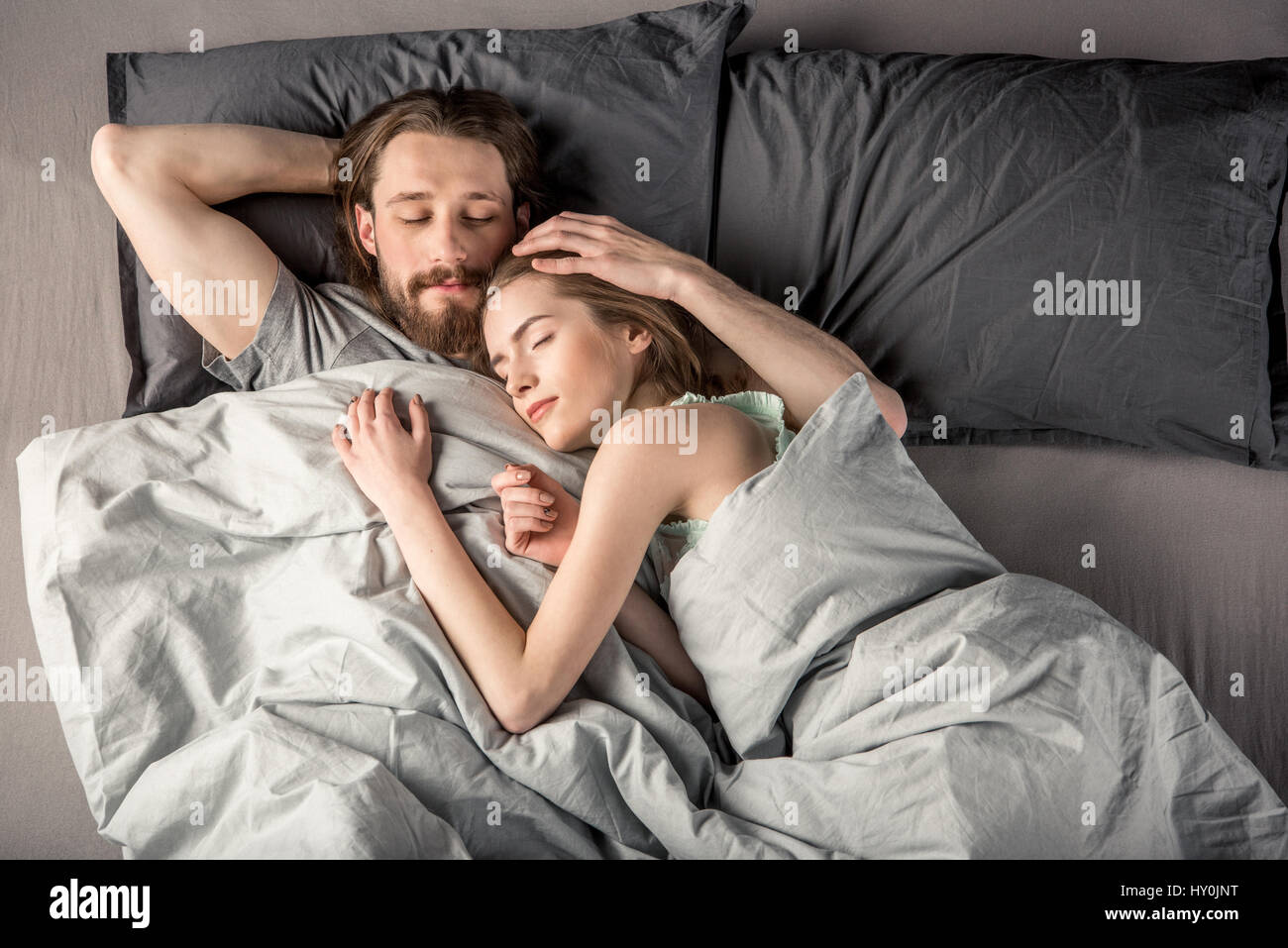 Draufsicht des jungen Paares schlafend im Bett Stockfoto