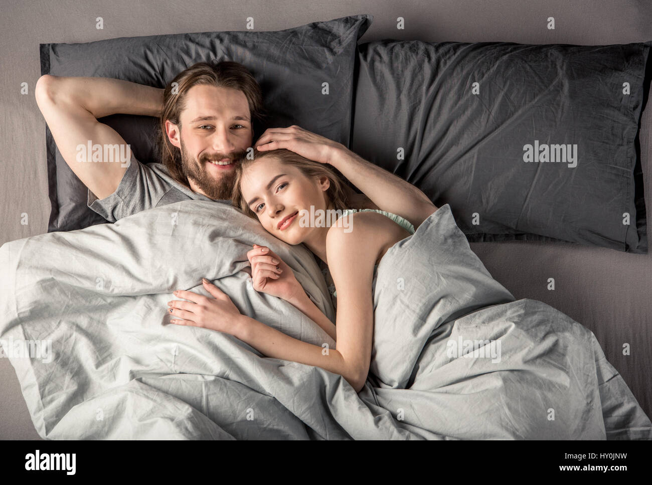 Draufsicht von jungen glücklichen Paar in Liebe im Bett liegend Stockfoto