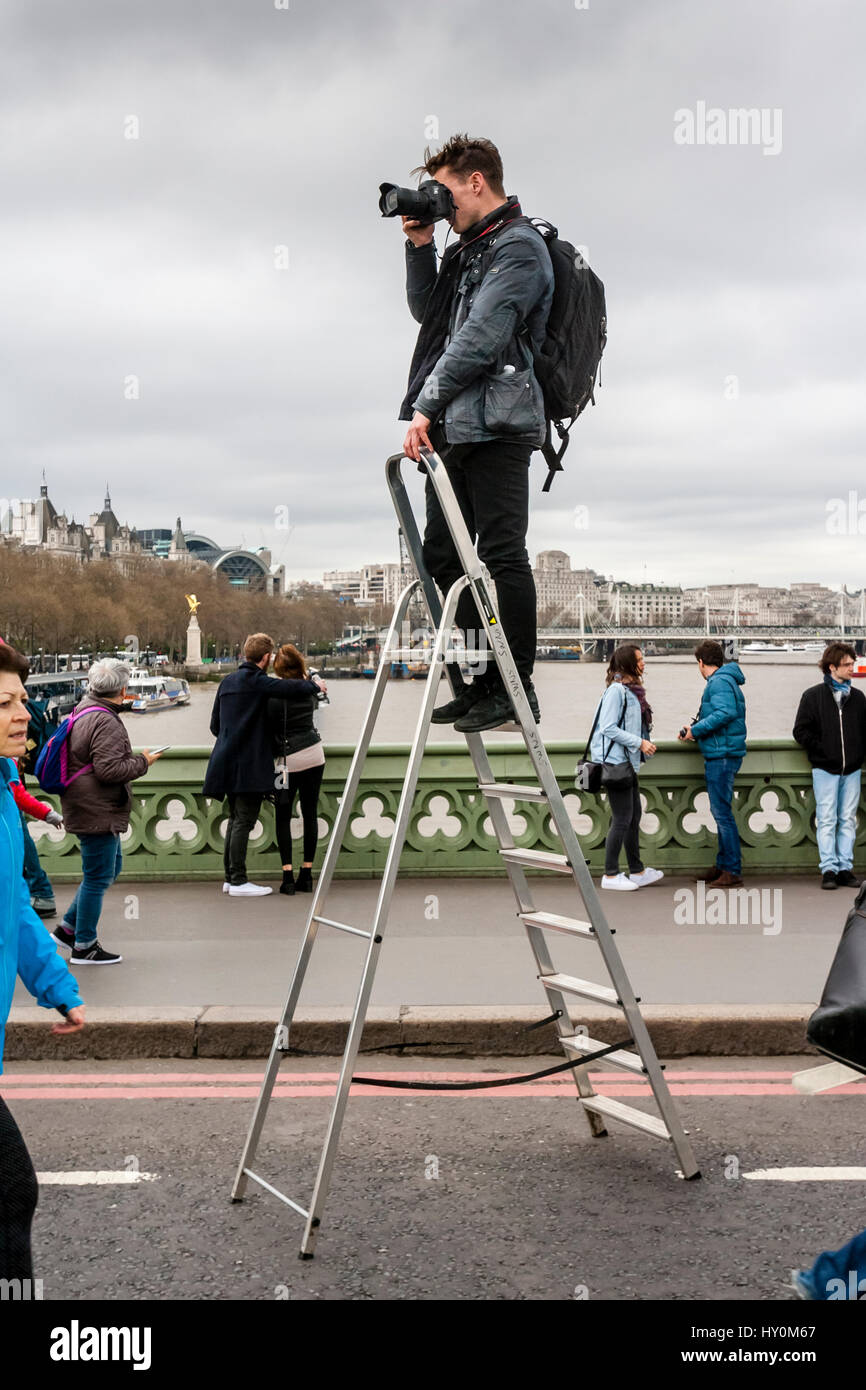 Ein Fotograf steht auf eine Trittleiter zum Fotografieren von Menschen auf Westminster Brücke ein Woche nach dem Terror-Anschlag, London, UK Stockfoto