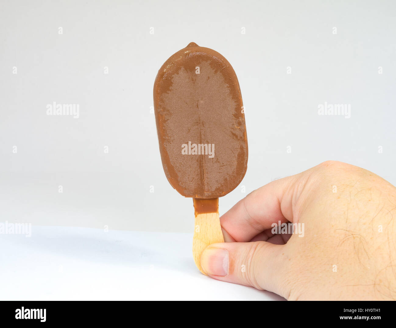 Meile Chocolate Choc Eis Eis auf einem Holzstab in einer Hand gehalten Stockfoto