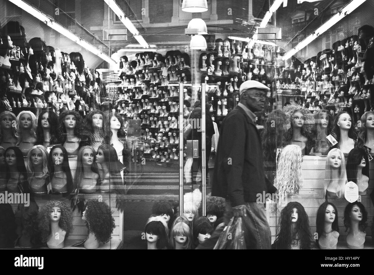 Mann, vorbei an einer Perücke Shop mit Schaufensterpuppen in London, Vereinigtes Königreich. Stockfoto