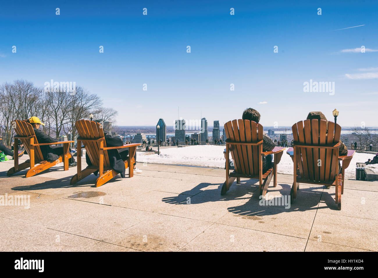 Montreal, CA - 30. März 2017: Menschen sitzen auf einem hölzernen Liegestuhl und genießen Sie einen sonnigen Frühlingstag auf Kondiaronk Belvedere Stockfoto