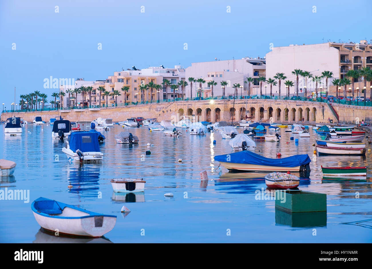 Die Ansicht der Marsaskala Waterfront und Marsaskala Bay mit den traditionellen maltesischen Fischerbooten im Abendlicht. Malta Stockfoto