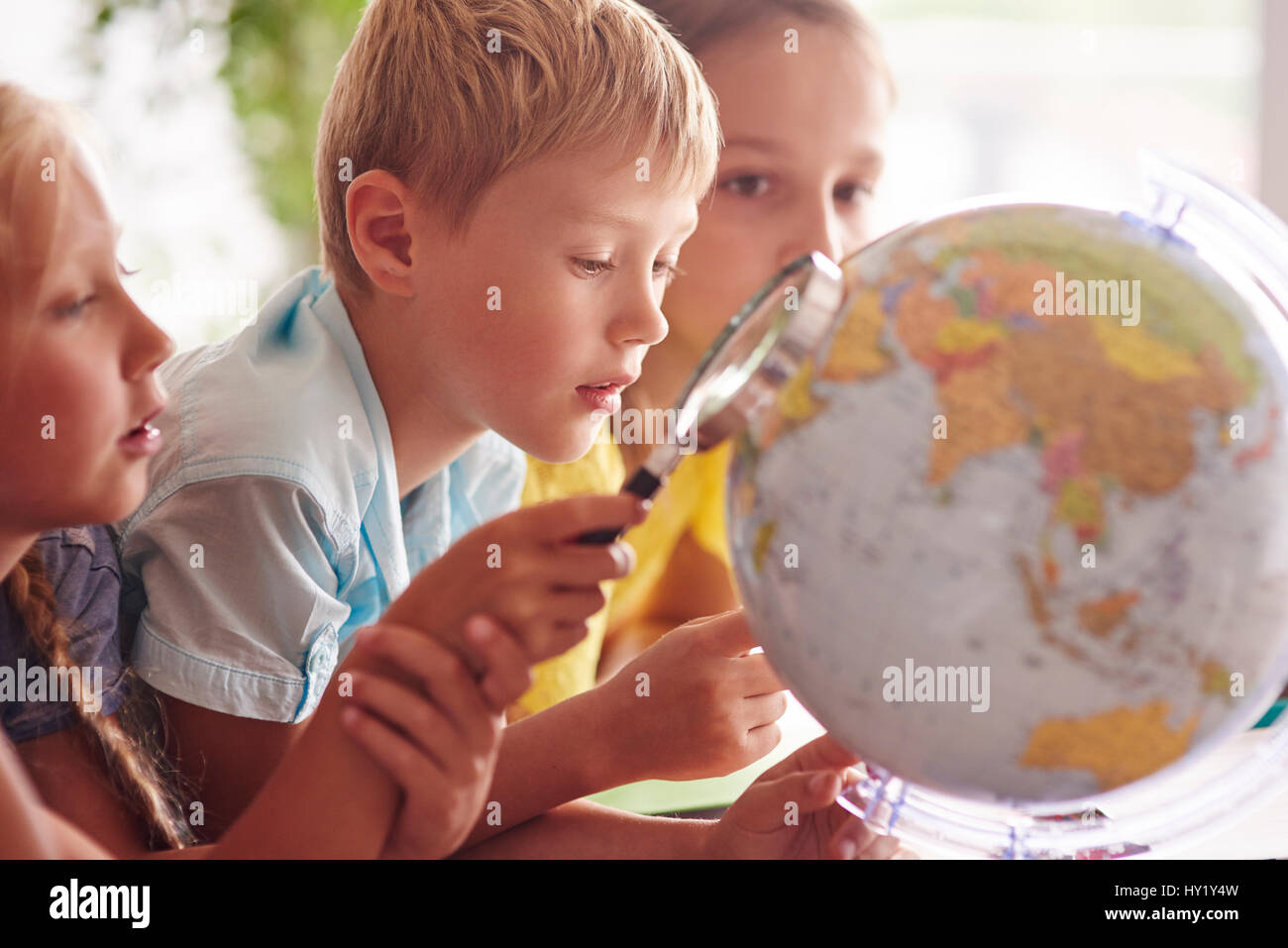 Kinder mit Lupe in Geographie Stockfoto