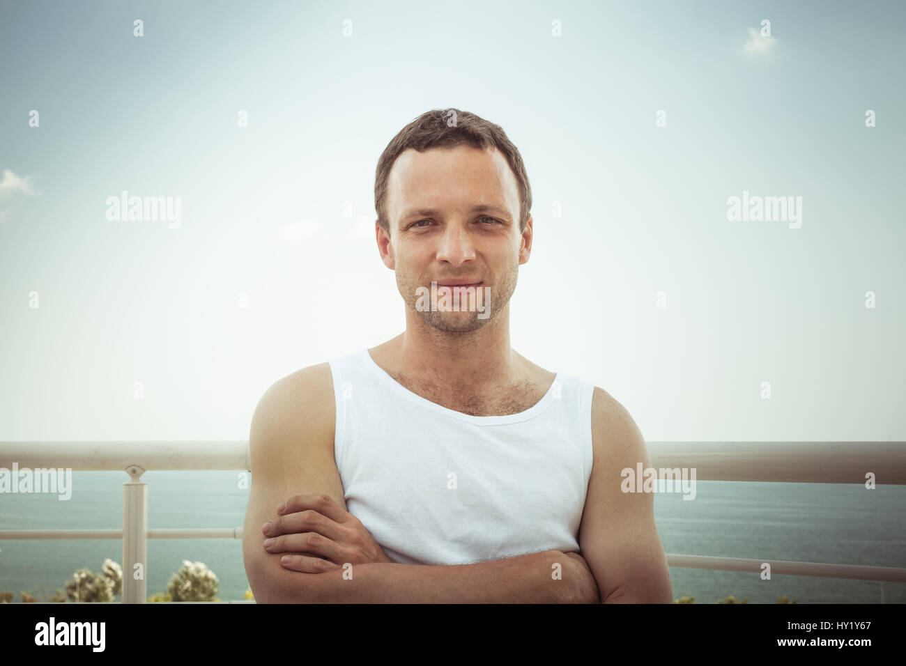 Outdoor Sommer Porträt der jungen sportlich lächelnder europäischen Mann im weißen Hemd, getönten Vintage Foto Stockfoto