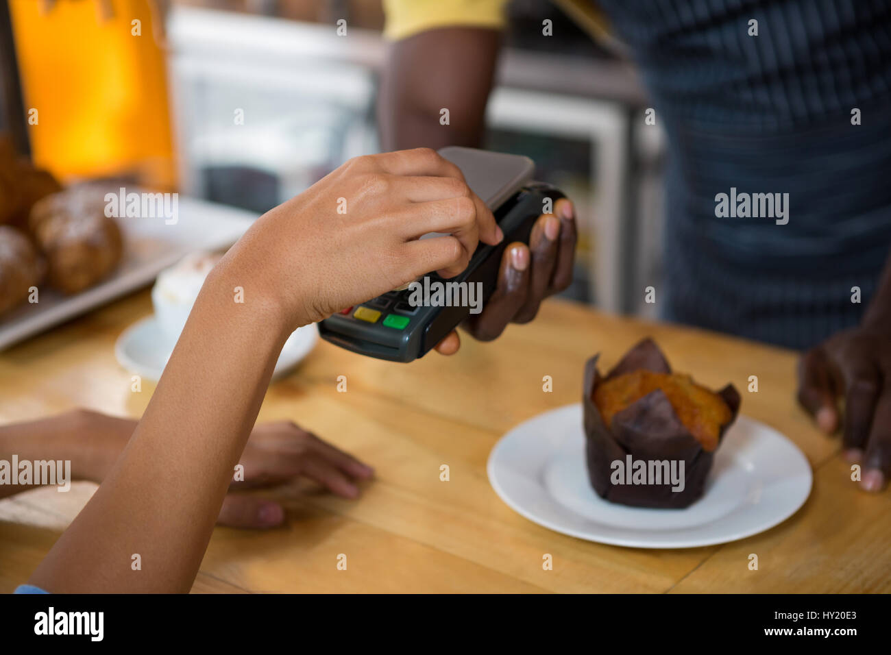Abgeschnitten Bild des Kunden zahlen Barista durch Smartphone in Coffee-shop Stockfoto