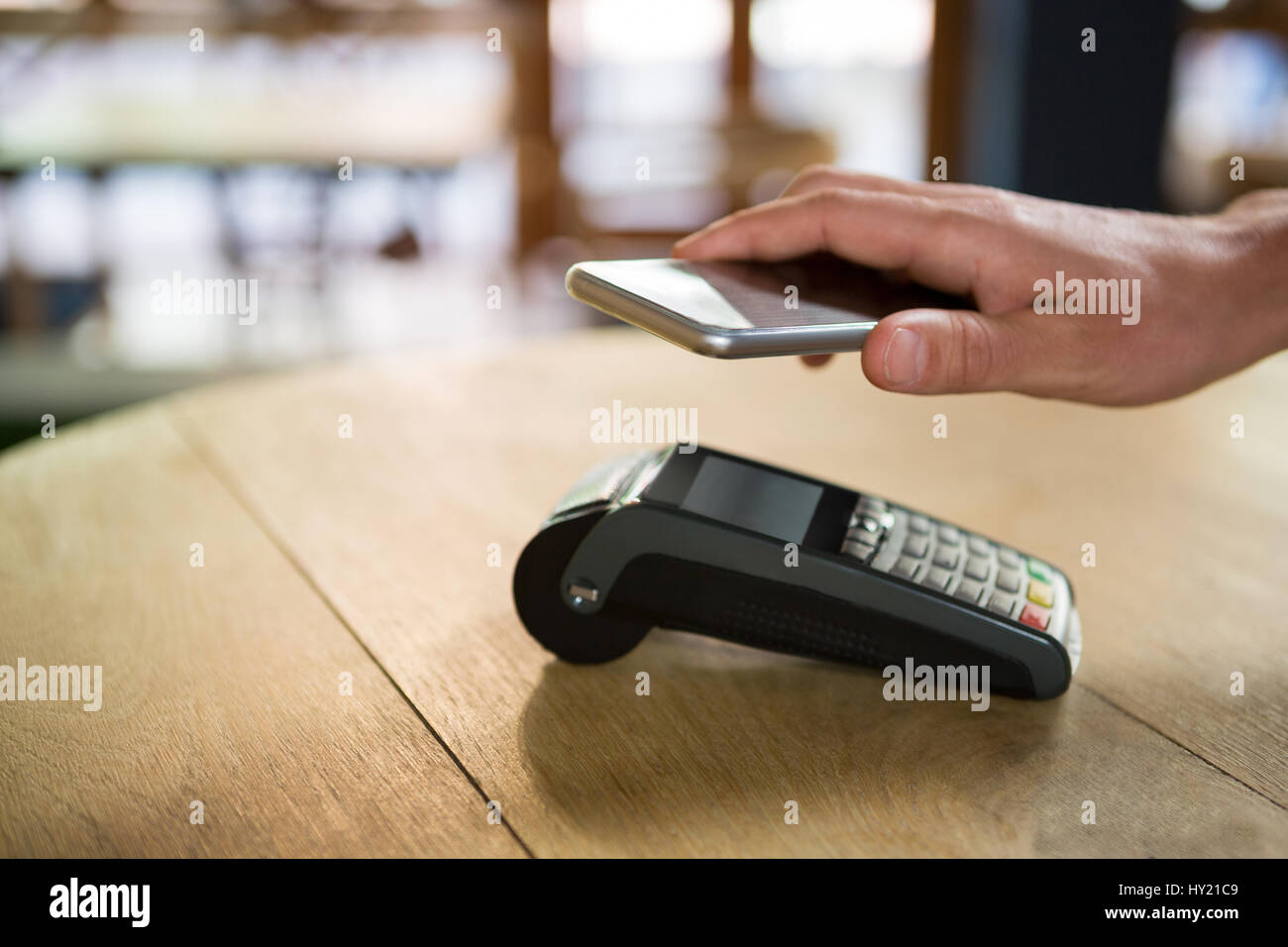 Bild von Hand durch Smartphone in Coffee-Shop bezahlen Kunden zugeschnitten Stockfoto