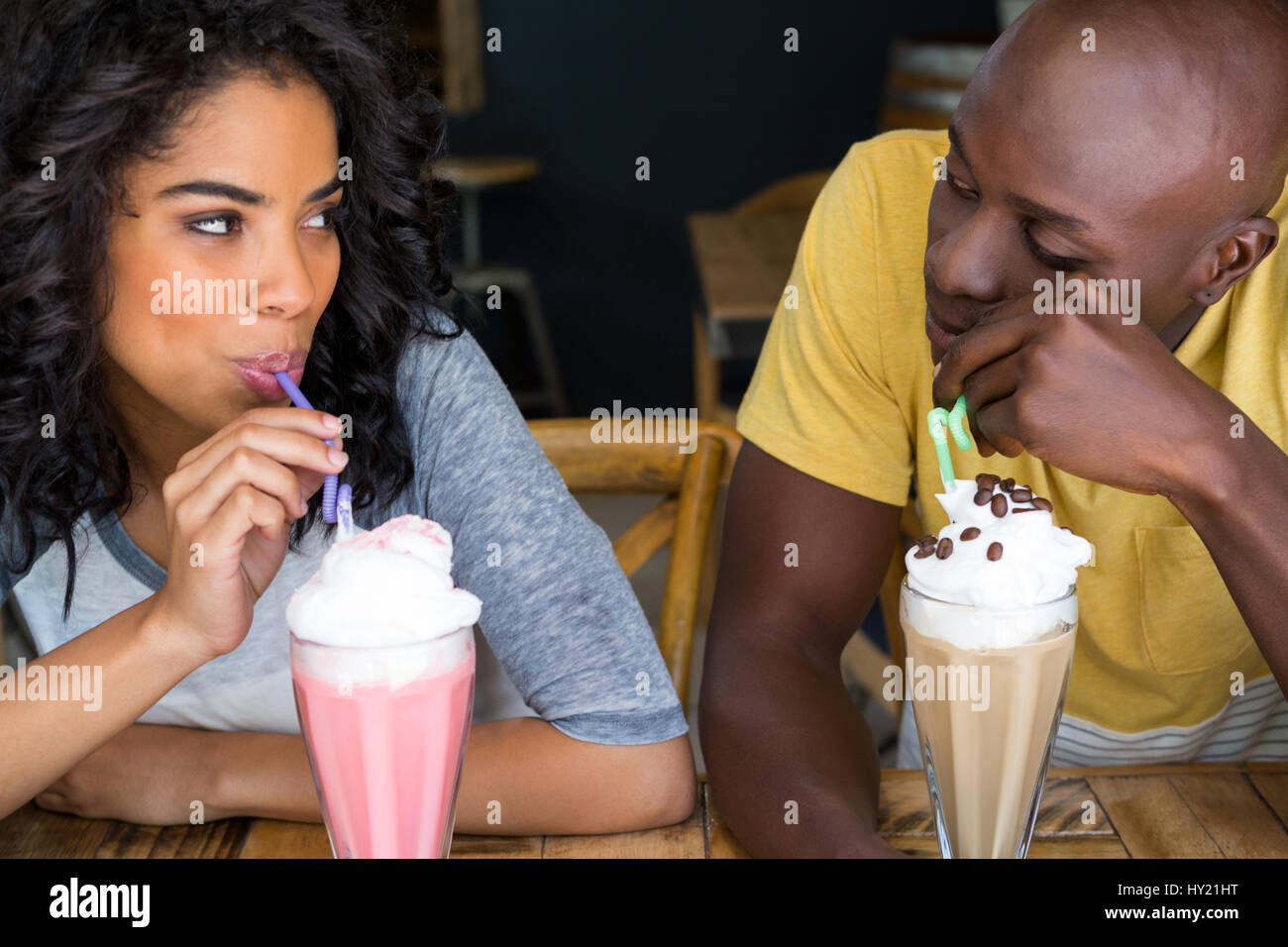 Liebevolle junge Paare, Milchshakes am Tisch im Café Stockfoto