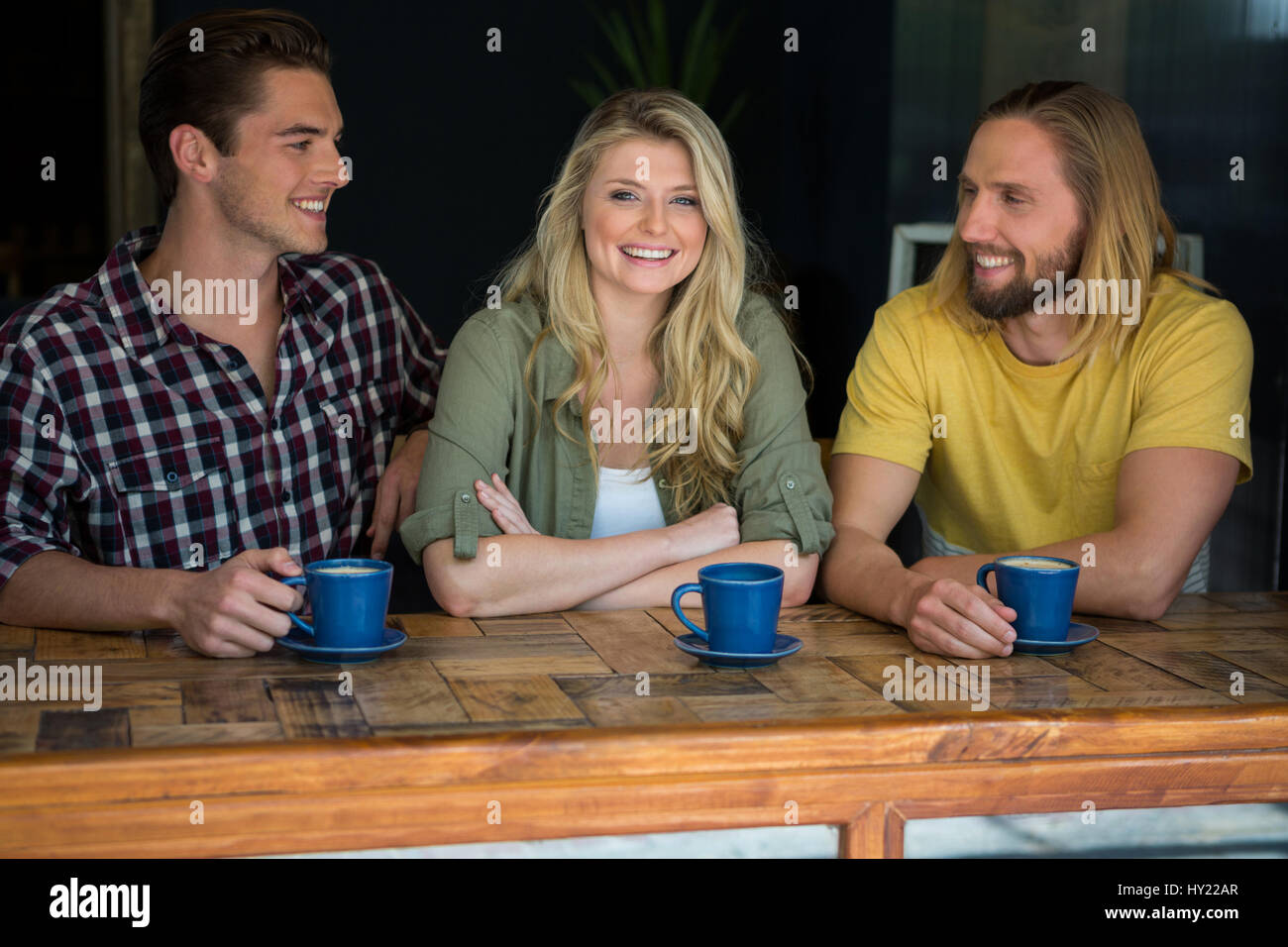 Portrait von glücklich Frau mit männlichen Freunden am Tisch im Café Stockfoto