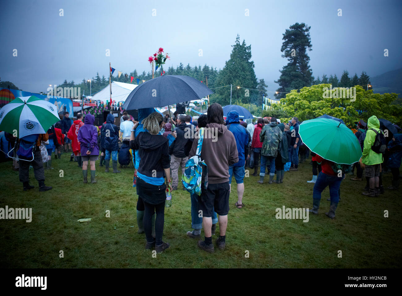Menschen, die gerade eine live-Band stehen unter einem Regenschirm mit  Blumen auf Spitze, Green Man-Festival, Wales Stockfotografie - Alamy