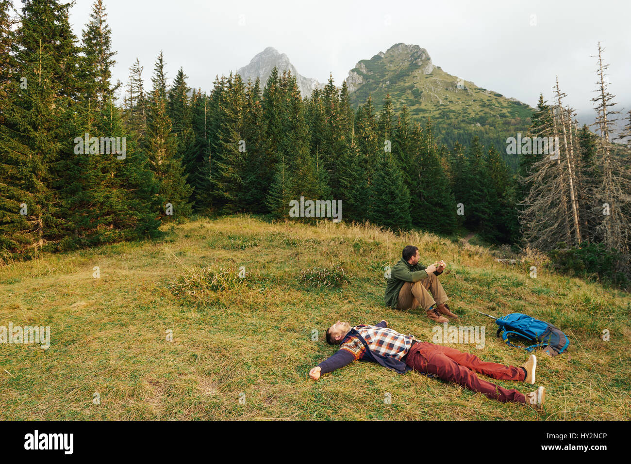 Erschöpfte Wanderer nach einer Wanderung auf dem Rasen liegend Stockfoto