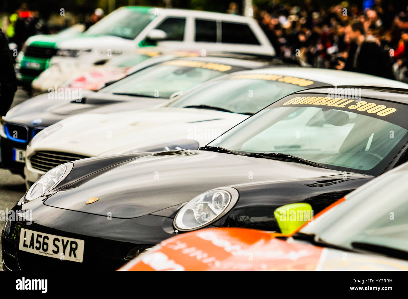 DUBLIN, Irland: 30. April 2016 - Autos, darunter ein Porsche 911 sind ein Aston Marton DBS, ein BMW M5 und einem Rangerover vor dem Start der Gumball Rally 3000 2016, von Dublin nach Budapest aufgereiht. Stockfoto