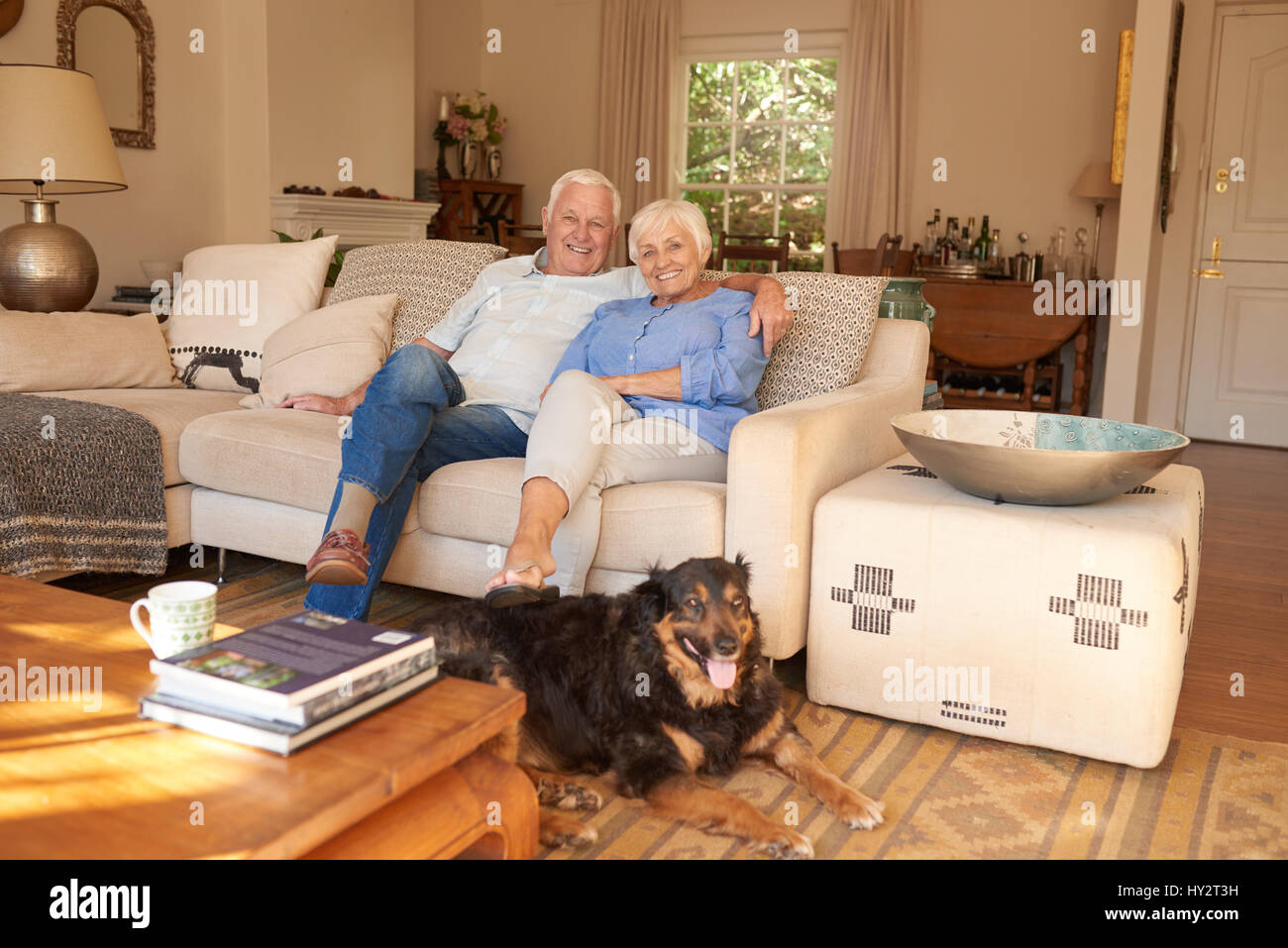 Content-älteres paar Entspannung zu Hause mit ihrem Hund Stockfoto
