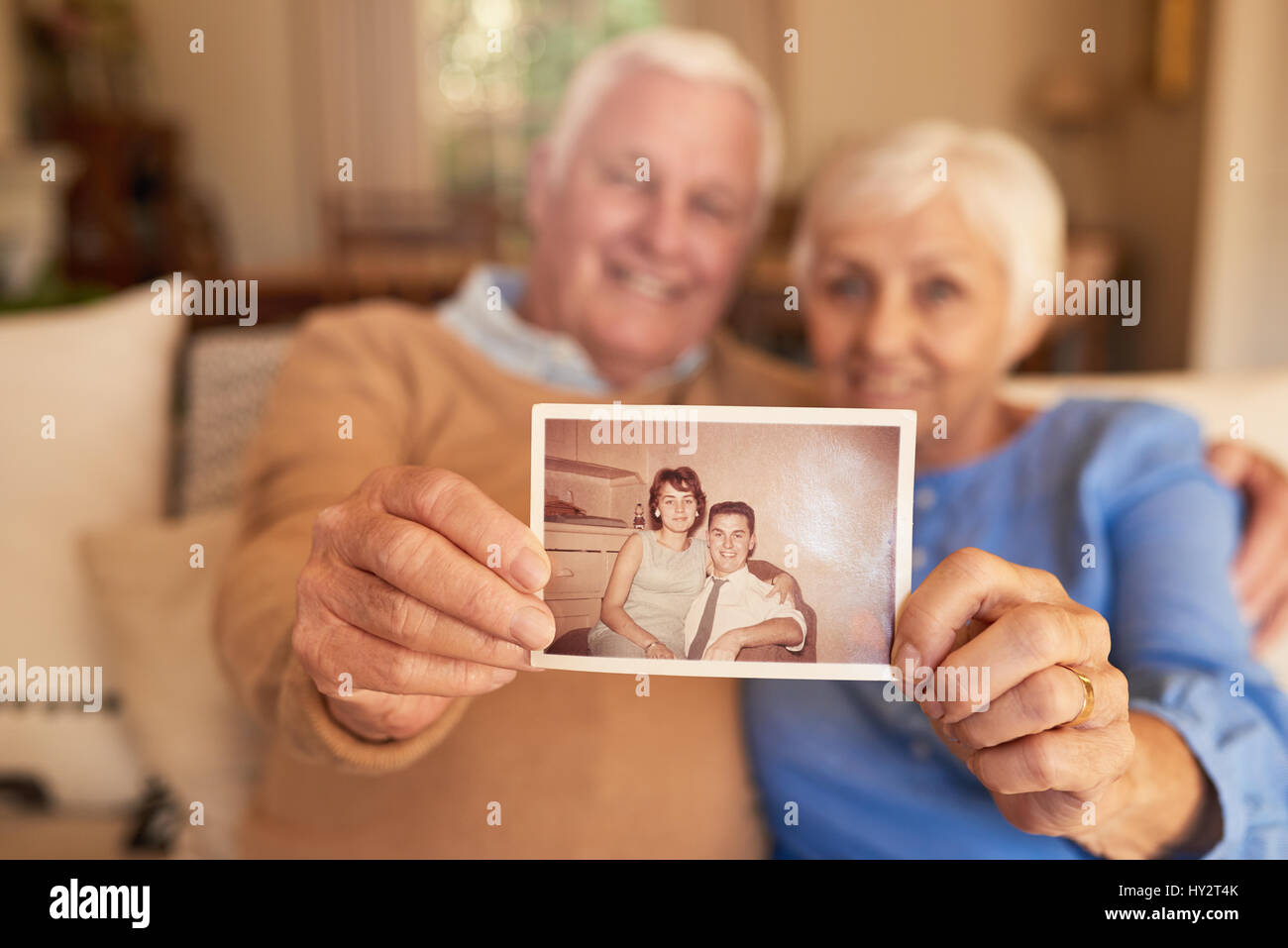 Inhalt älteres Paar hält ein Foto von ihr jugendliches selbst Stockfoto