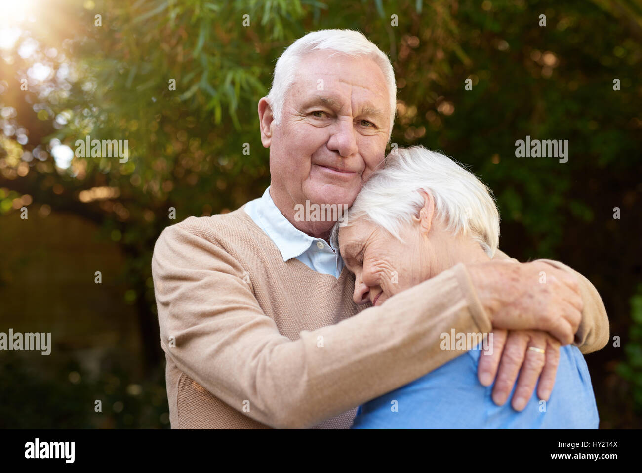 Inhalt senior Mann liebevoll umarmt seine Frau draußen Stockfoto