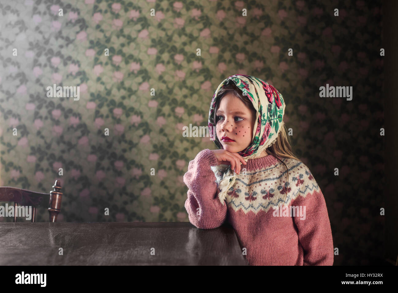 Schweden, Portrait eines Mädchens (4-5) verkleidete sich als Ostern Hexe stützte sich auf Tisch Stockfoto