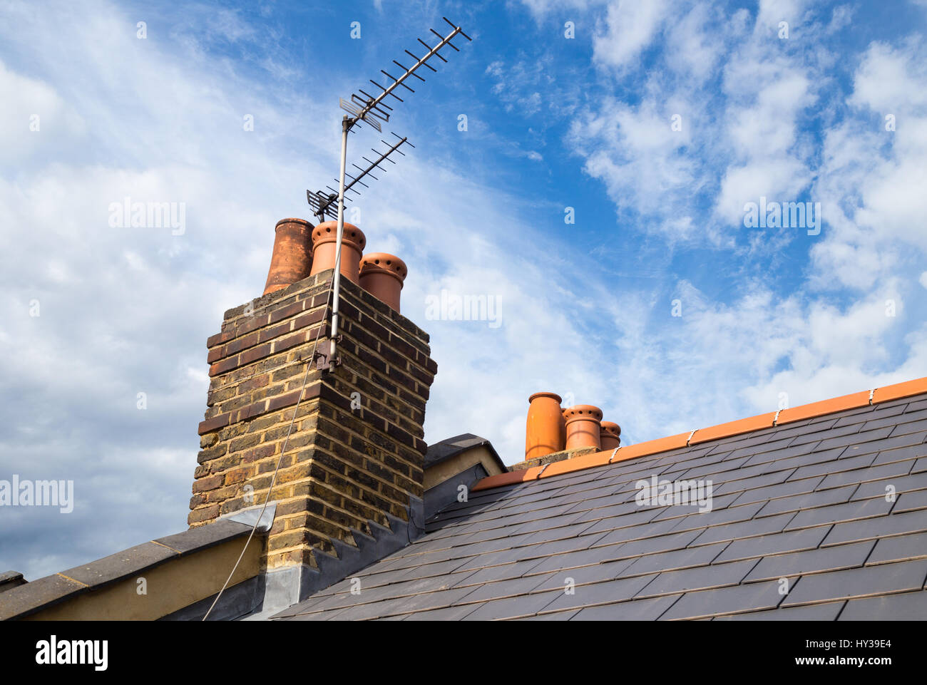 Ziegeldach, Kamin und TV Antenne des viktorianischen Reihenhaus in Nord-London Stockfoto