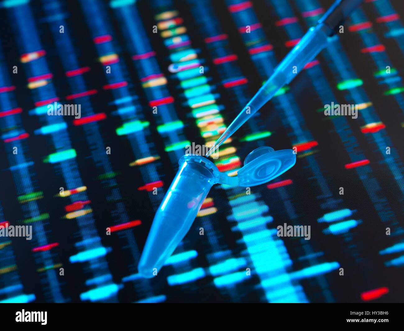 Pipette Zugabe der Probe in ein Fläschchen für Gentests, mit Ergebnissen im Hintergrund. Stockfoto
