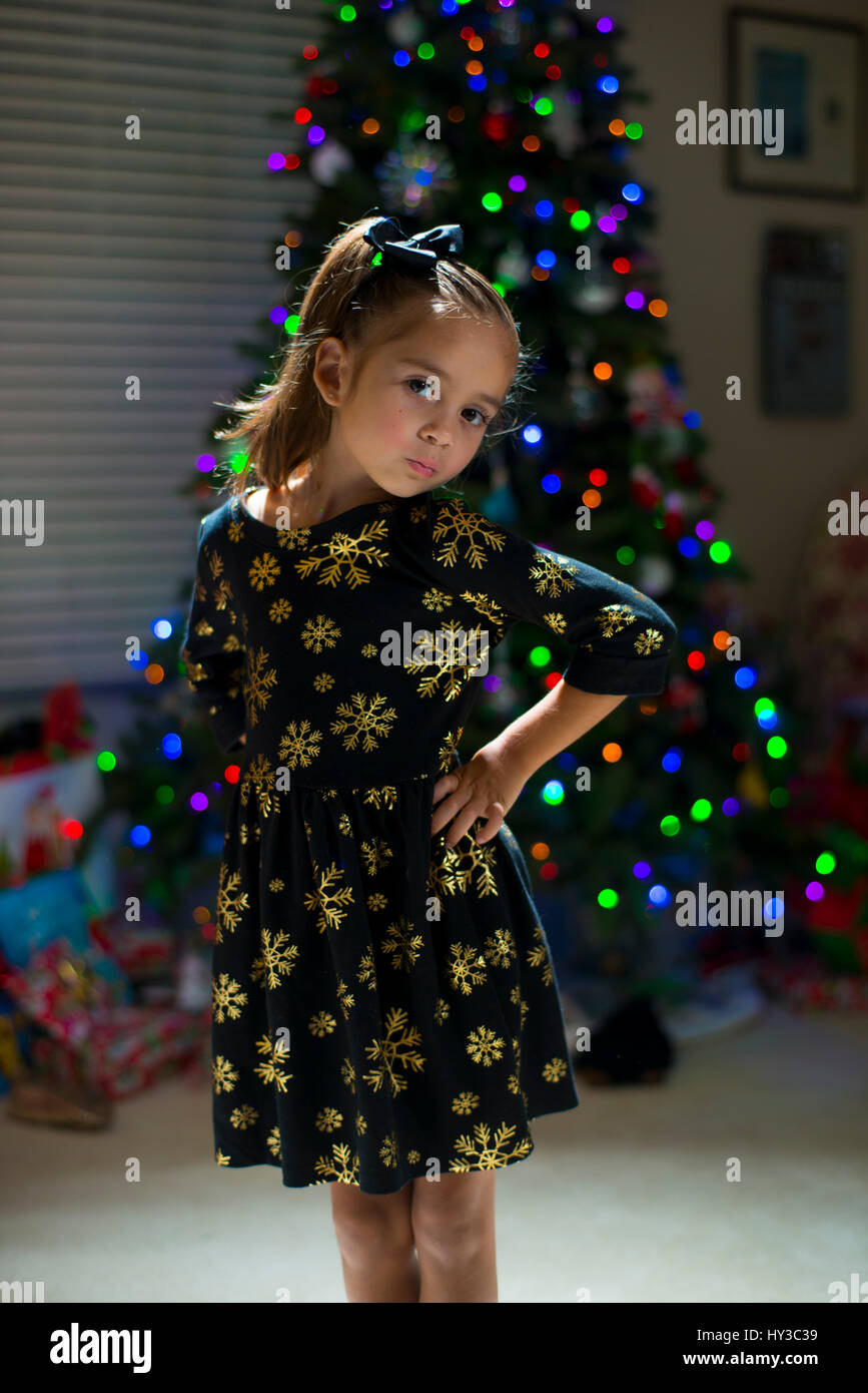 kleines Mädchen lächelnd posiert Weihnachtsbaum Stockfoto