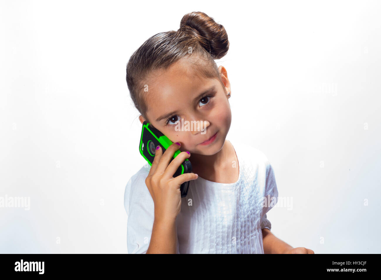 junges Mädchen im Studio weiß auf weiß mit Telefon Stockfoto