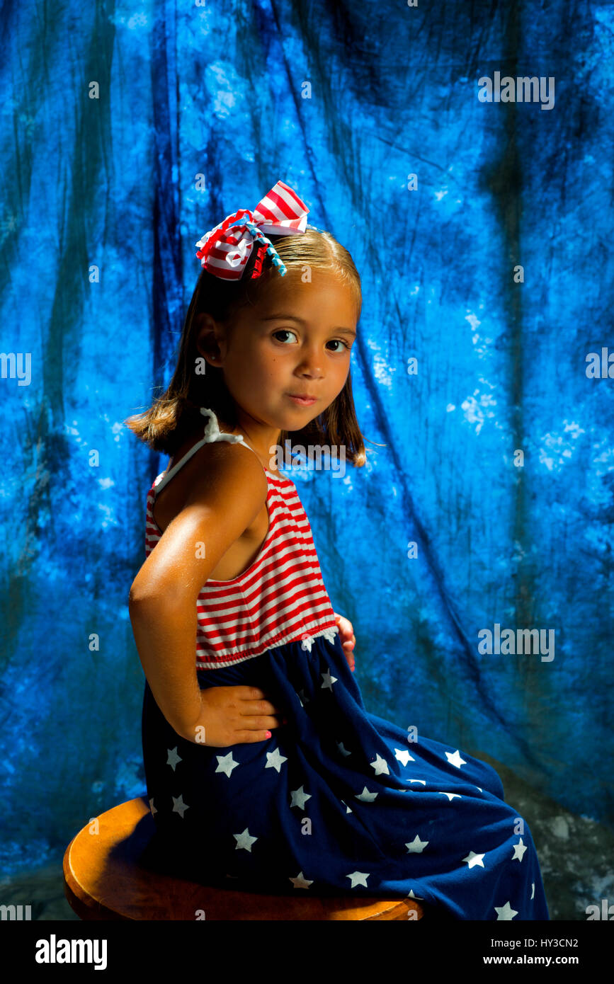 kleines Mädchen im Studio posiert mit Urlaub Farben auf rot weiß blau 4. Juli Stockfoto