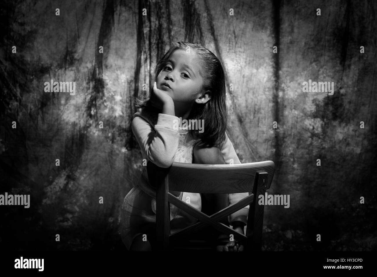 junges Mädchen im Studio posieren Goldgrund sitzen im Stuhl untersucht Cam schwarz & weiß Stockfoto