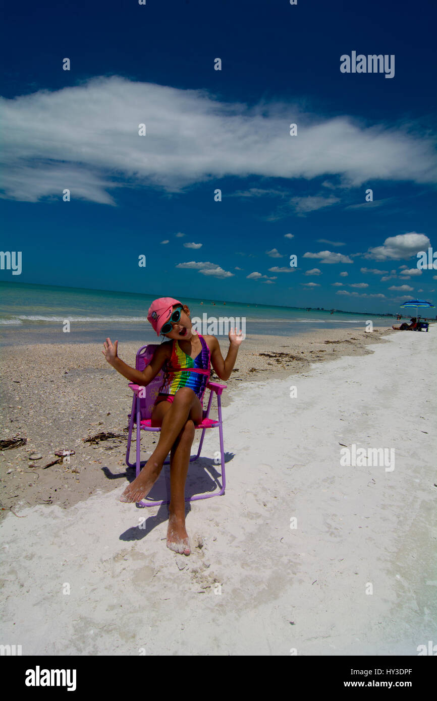 junges Mädchen am Strand sitzen in ihren Strandkorb posiert für die Kamera Stockfoto