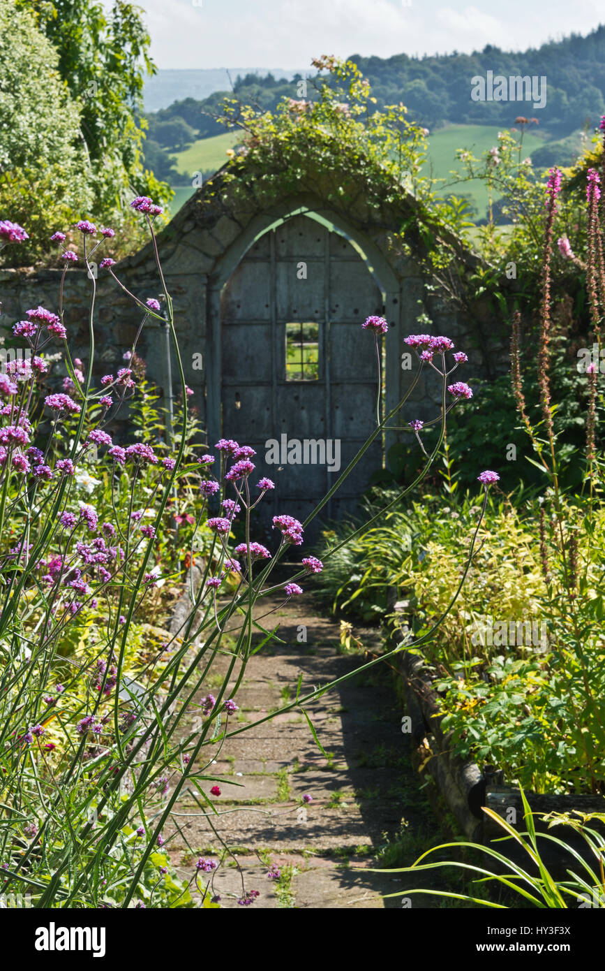 Alte Holztür und Stein Bogen Burrow Farm Gardens, auch bekannt als Osten Devons Secret Garden, in der Nähe von Axminster, Devon, England, UK Stockfoto