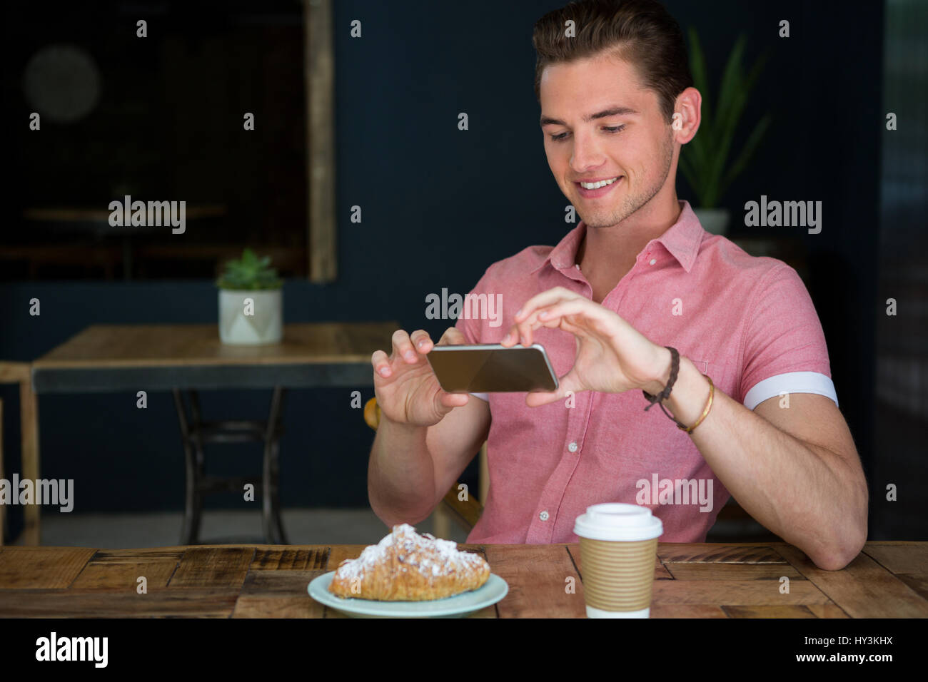 Glücklich Jüngling fotografieren Essen am Tisch im Café Stockfoto