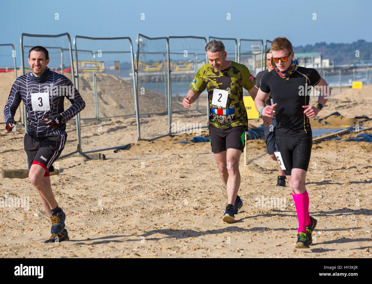 Männer, die Teilnahme an Sandsturm Herausforderung in Bournemouth im März Stockfoto