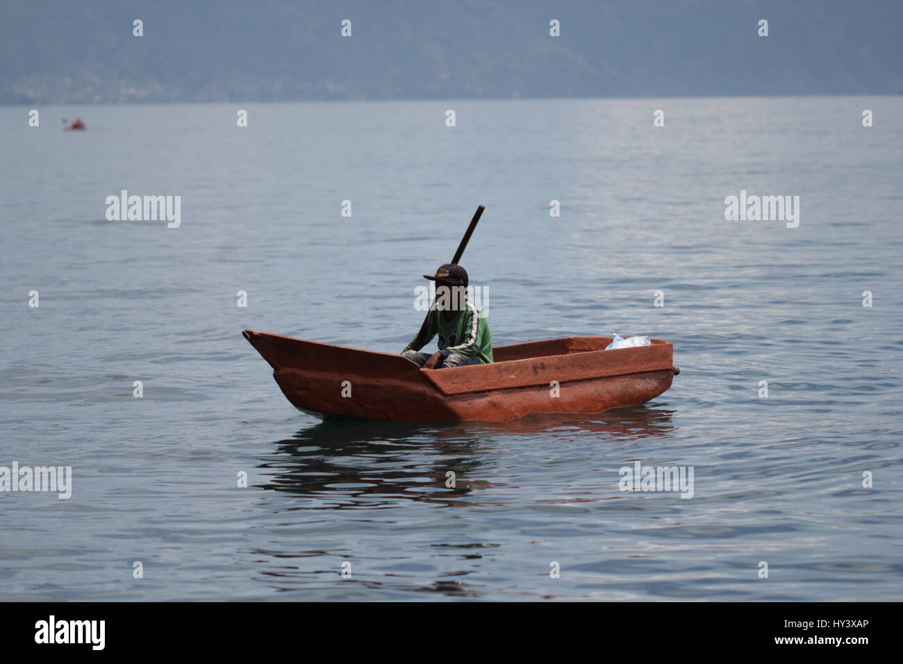 Fischer auf seine eigene Handarbeit gebaut Holzboot in See Lake Atitlan, Guatemala Stockfoto