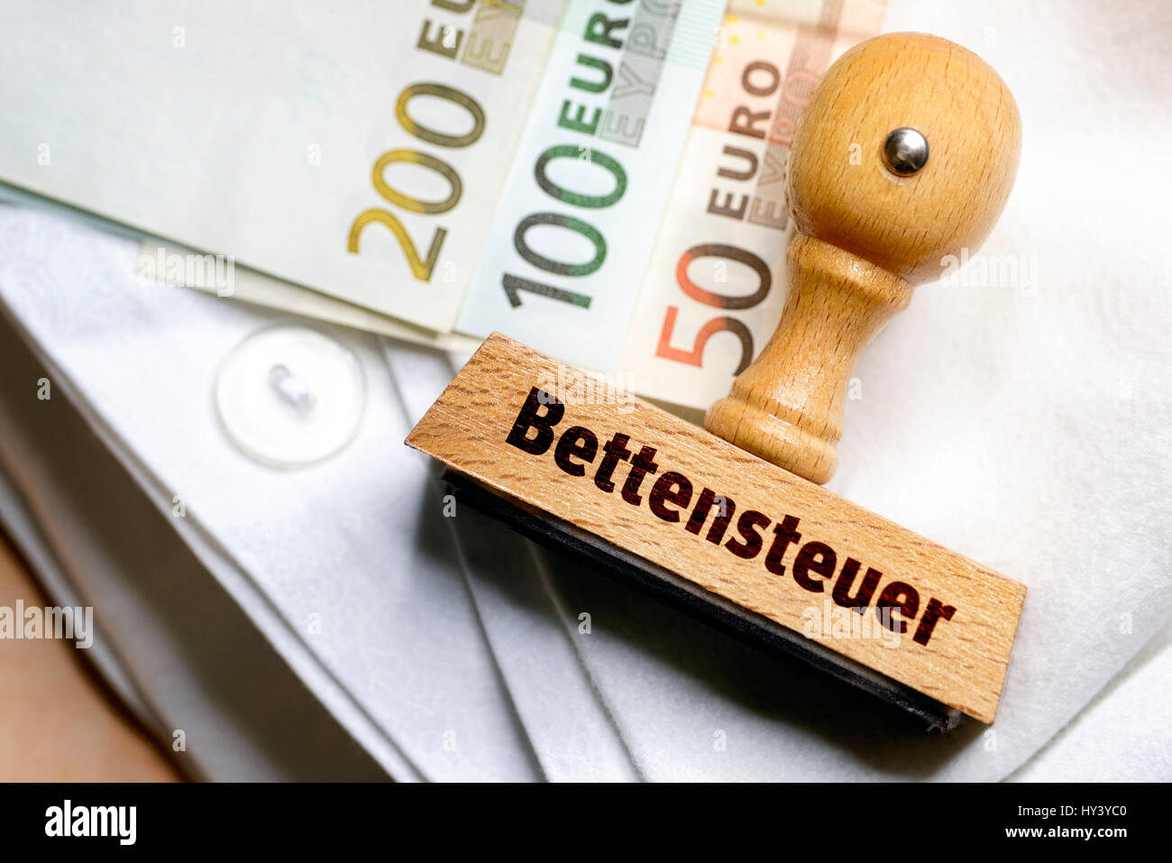 Stempel mit Label Bett-teuer und Banknoten auf einem Blatt, Stempel Mit Aufschrift Bettensteuer Und Geldscheine Auf Einem Bettlaken Stockfoto