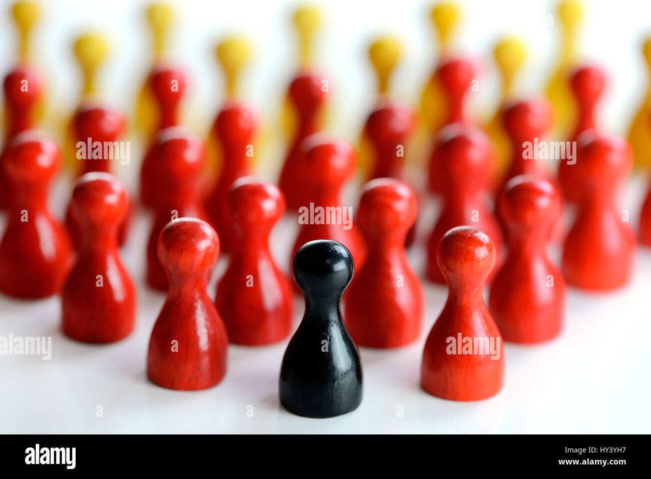 Schwarz Spielfigur vor vielen roten und gelben Figuren, symbolische Foto für Populismus in Deutschland, Schwarze Spielfigur Vor Vielen Roten Und Klingebiel Skulpturengruppe, Stockfoto