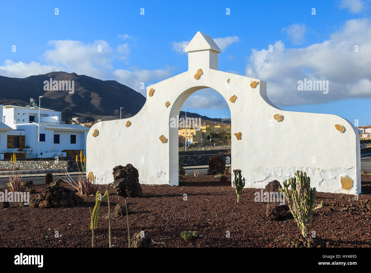 Typische Gemeinde melden (weißes Tor Bogens) in Gran Tarajal Dorf mit Wüstenlandschaft im Hintergrund, Fuerteventura, Kanarische Inseln, Spanien Stockfoto
