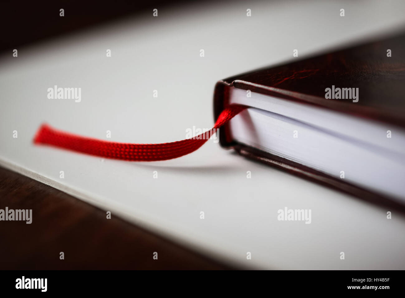 Eine schöne Nahaufnahme eines Buches in dunkle rote Abdeckung und mit roten Lesezeichen. Geringe Schärfentiefe Stockfoto