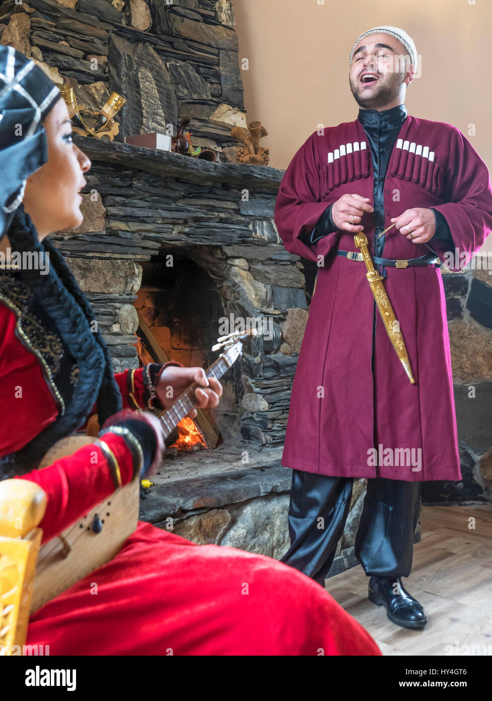Paar im traditionellen dress Durchführung einer georgischen Volkslied in Ushguli Guest House, Ushguli, Caucasus Bergdorf. Stockfoto
