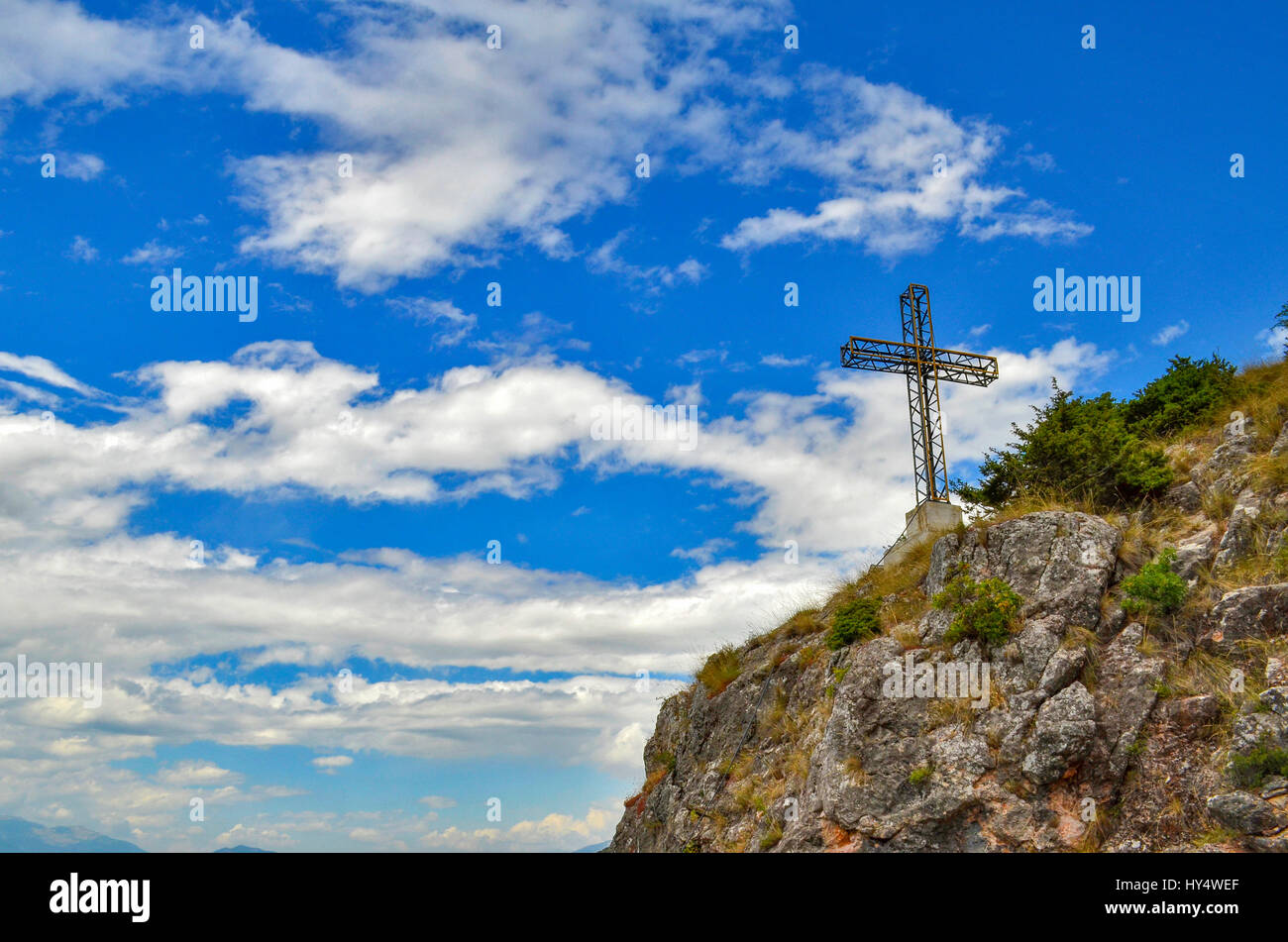 Kreuz am Berg mit bewölkten blauen Himmel im Hintergrund Stockfoto