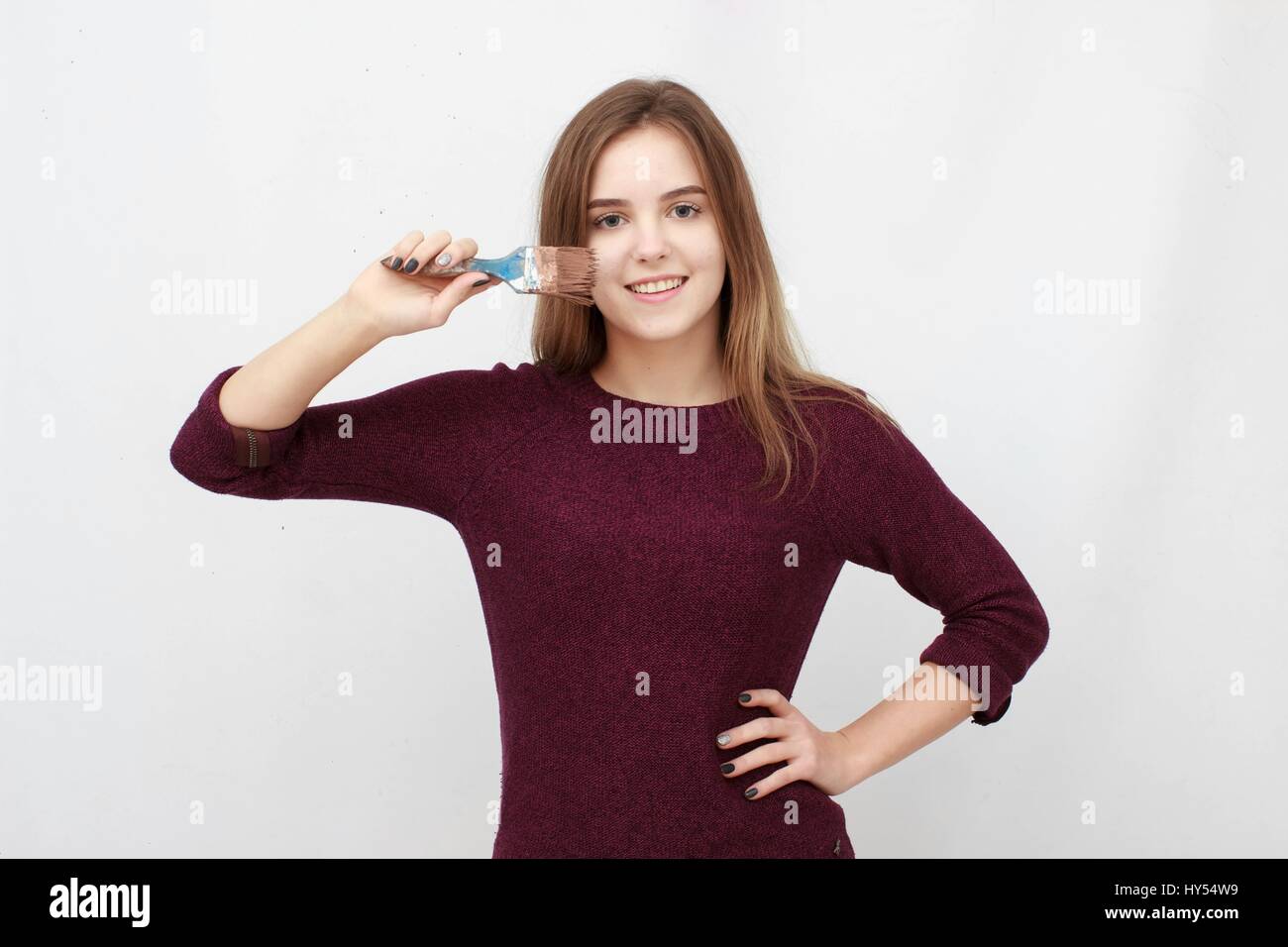 Gesicht der jungen Malerin mit einem Pinsel über ihr Gesicht Nahaufnahme Stockfoto