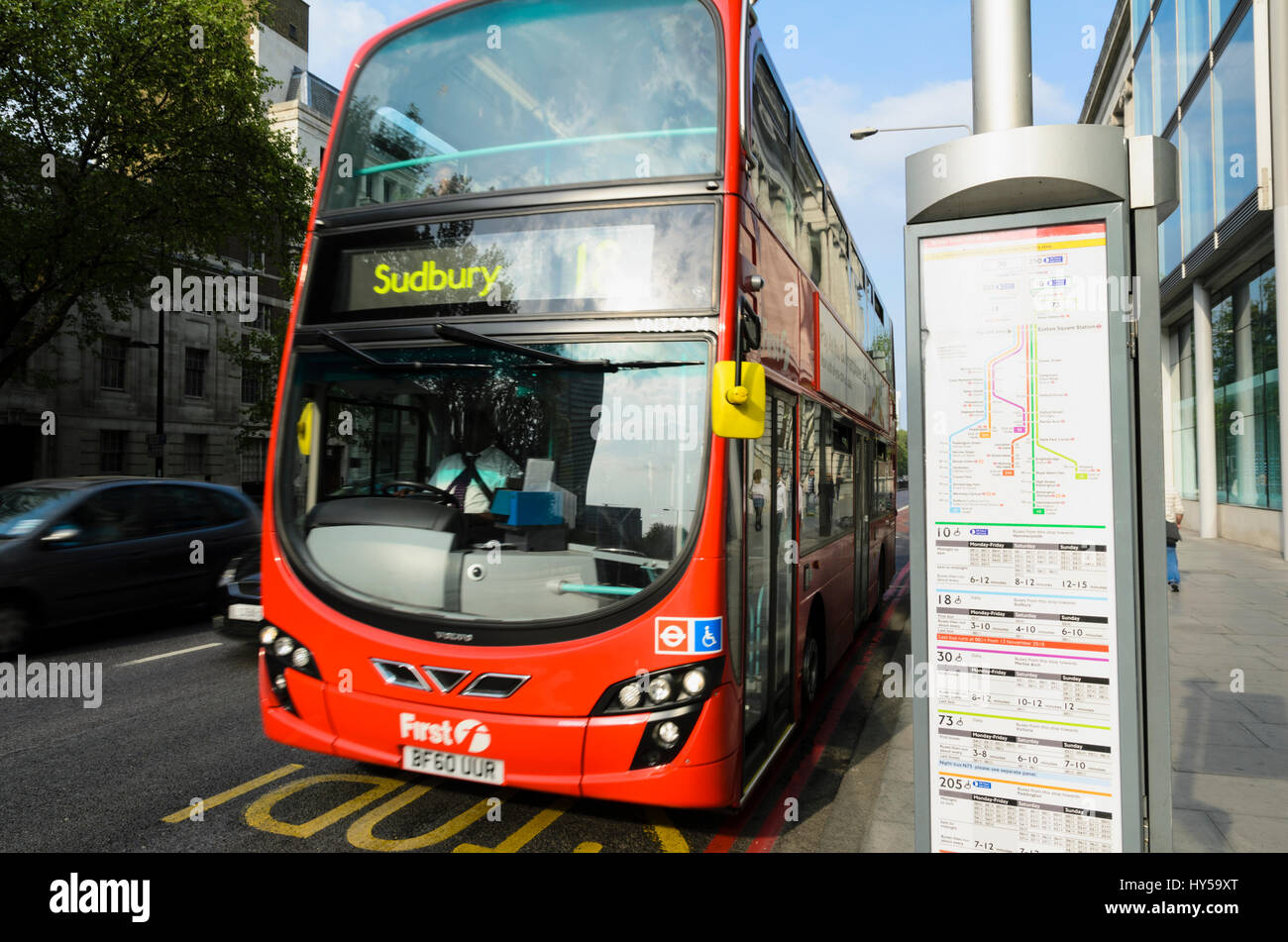 Ein roten Doppeldeckerbus London übergibt eine Bushaltestelle zeigt eine stilisierte Karte und Fahrpläne. Bus-Frequenzen; öffentliche Verkehrsmittel in Großbritannien, britische bus Stockfoto
