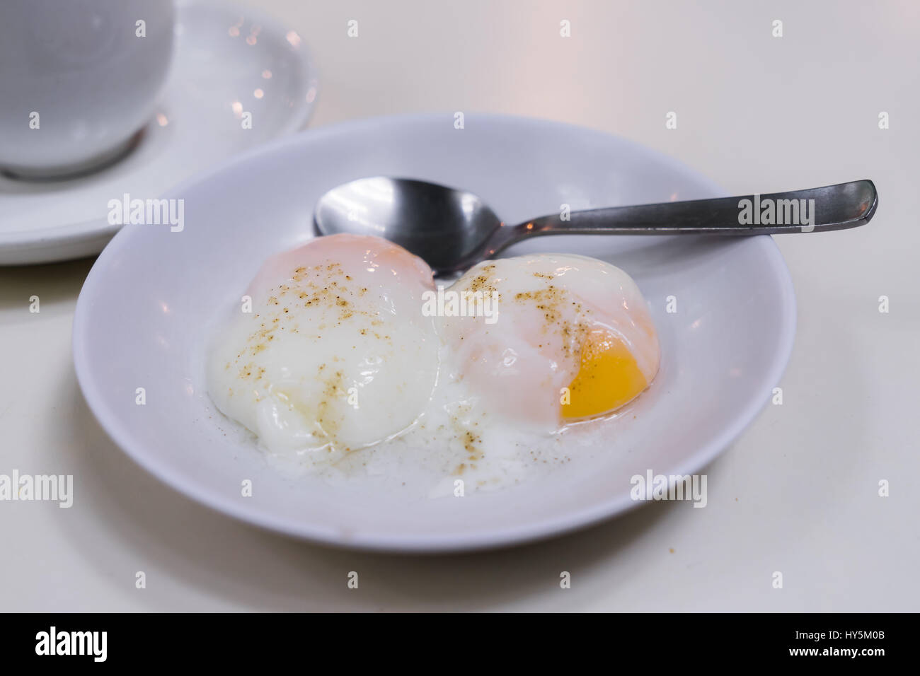 Halben gekochten Eiern, traditionelle Singapur Frühstück rief Kaya Toast, Original Brot zu toasten mit Kaya eine lokale Marmelade aus Eiern, Zucker und Kokosmilch Stockfoto