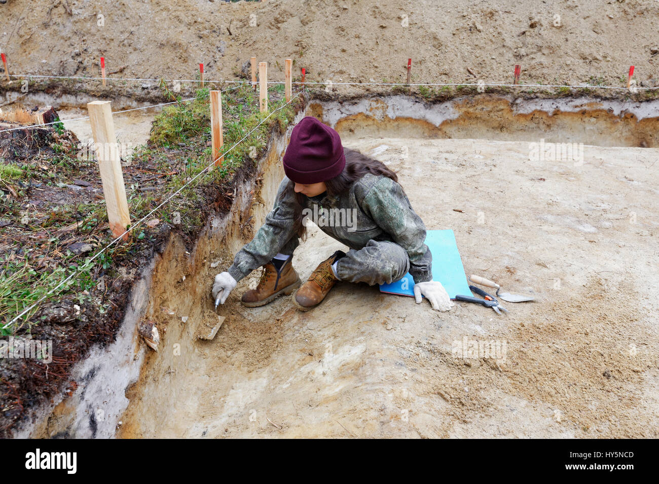 Mädchen-Archäologe reinigt eine Wand in der Baugrube Stockfoto