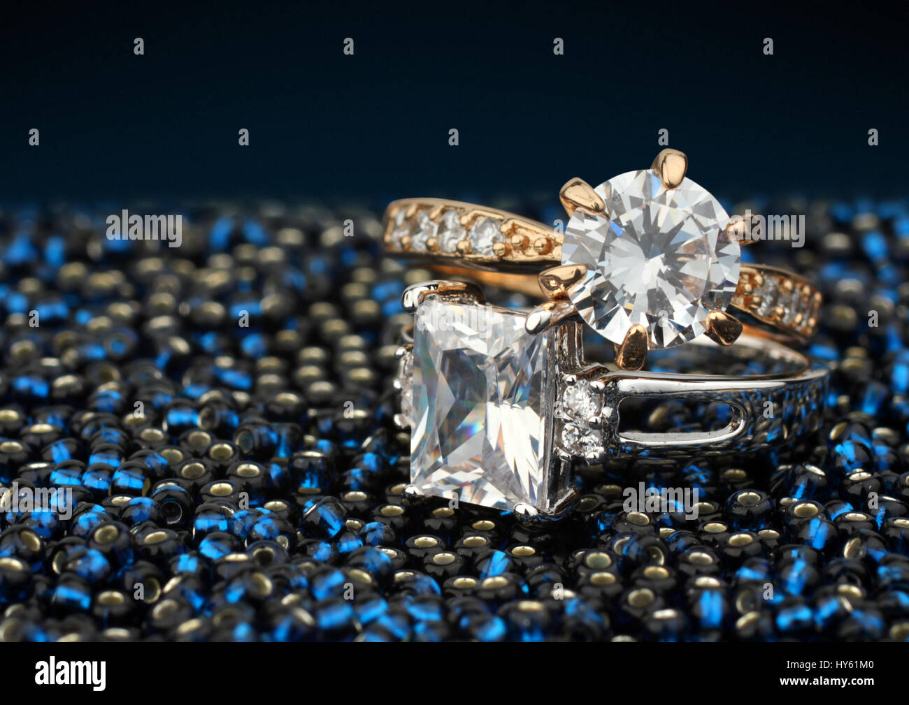 Paar Schmuck Ringe mit großen Diamanten auf blauem Hintergrund Stockfoto