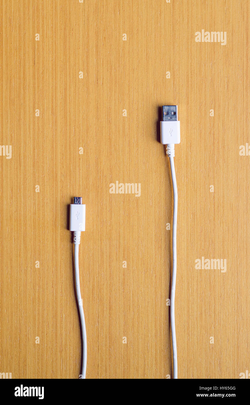 Weiße USB-Kabel mit standard und Mikro-Anschluss auf dem hölzernen Hintergrund vertikale Stockfoto