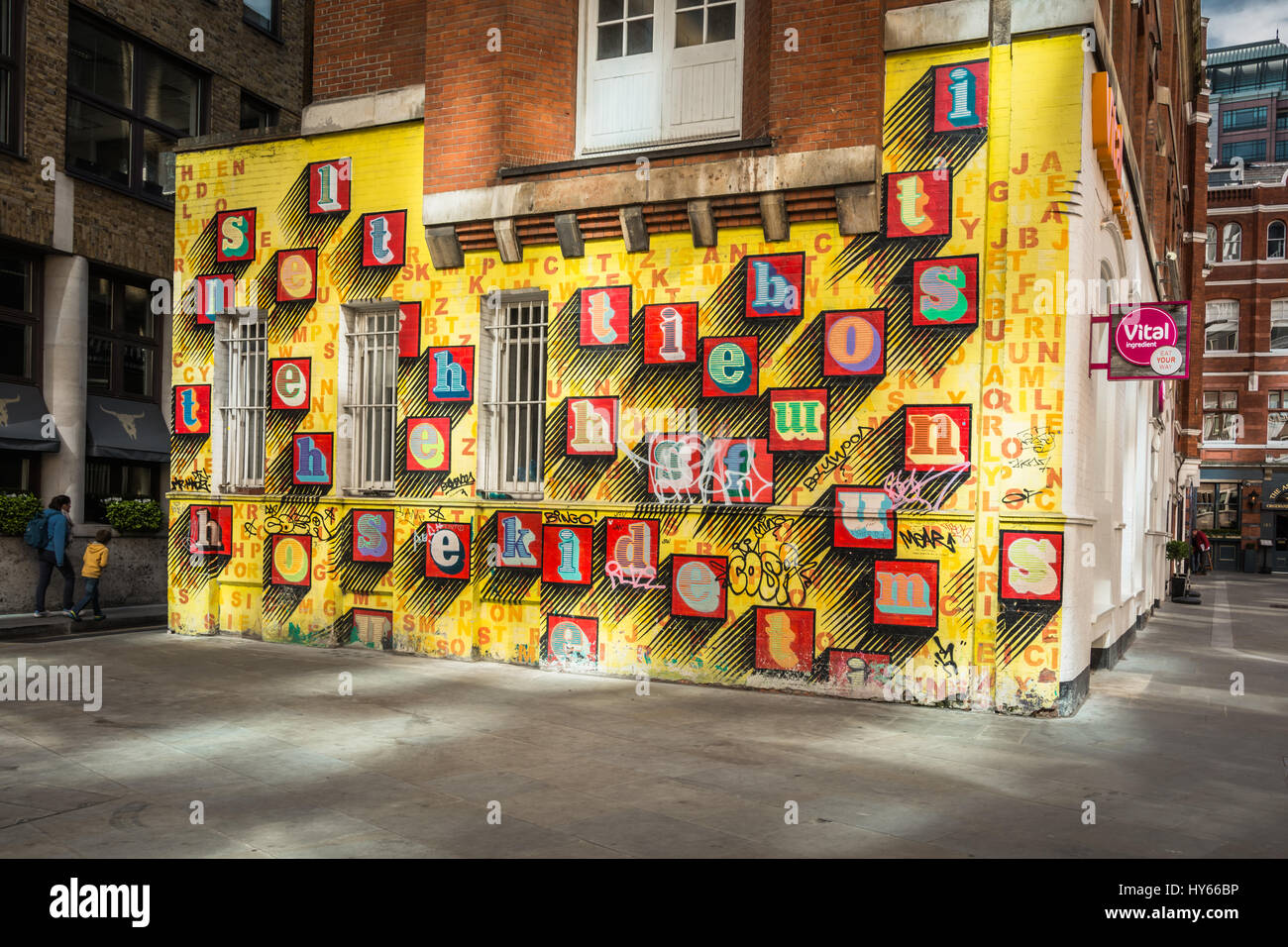 „Alphabet House“ Street Art von Ben eine – farbenfrohe Buchstaben auf einer gelben Wand in Spitalfields, London, England, Großbritannien Stockfoto