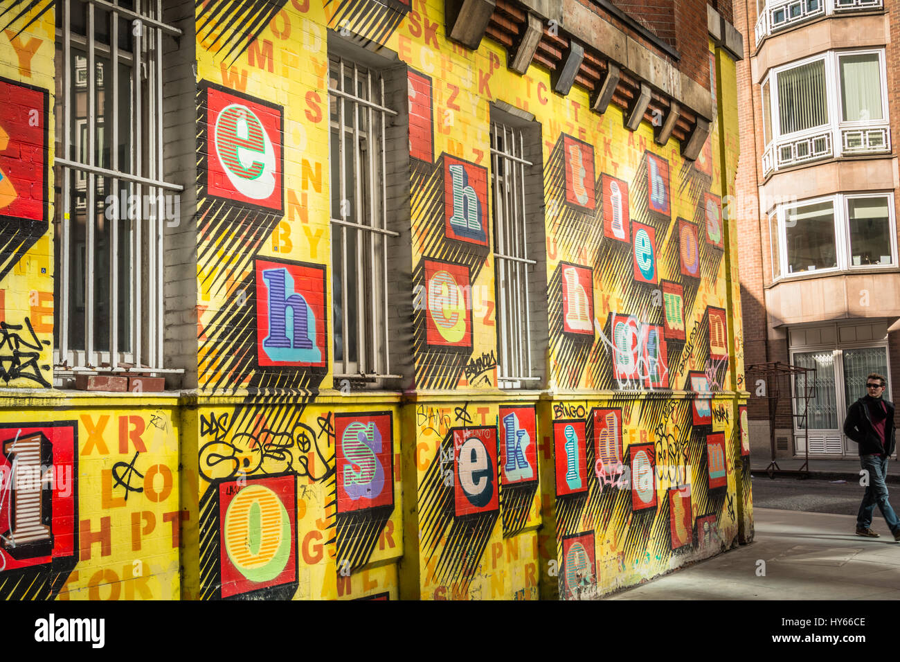 „Alphabet House“ Street Art von Ben eine – farbenfrohe Buchstaben auf einer gelben Wand in Spitalfields, London, England, Großbritannien Stockfoto