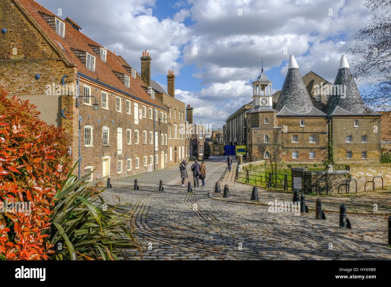 Drei Mühlen-Insel, Eastend von London, aufgenommen an einem sonnigen Frühlingstag und zeigt die Mühle und das Haus mit gepflasterten Steinen. Stockfoto