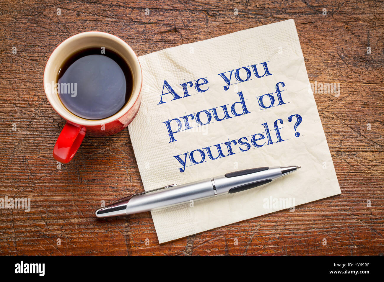 Bist du stolz auf dich Frage - Handschrift auf einer Serviette mit einer Tasse Espresso-Kaffee Stockfoto