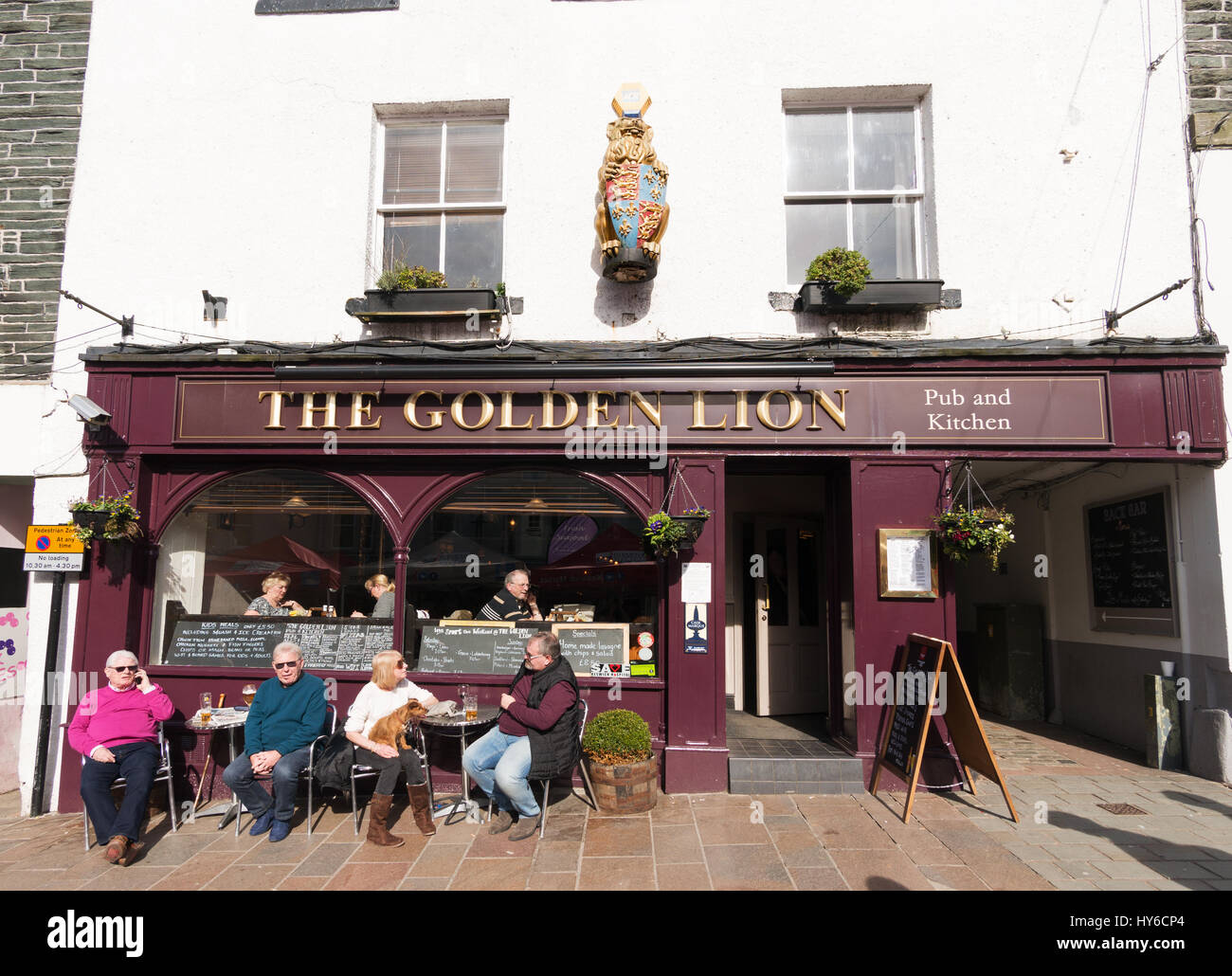 Menschen sitzen vor den The Golden Lion Pub in Keswick, Cumbria, England, UK Stockfoto
