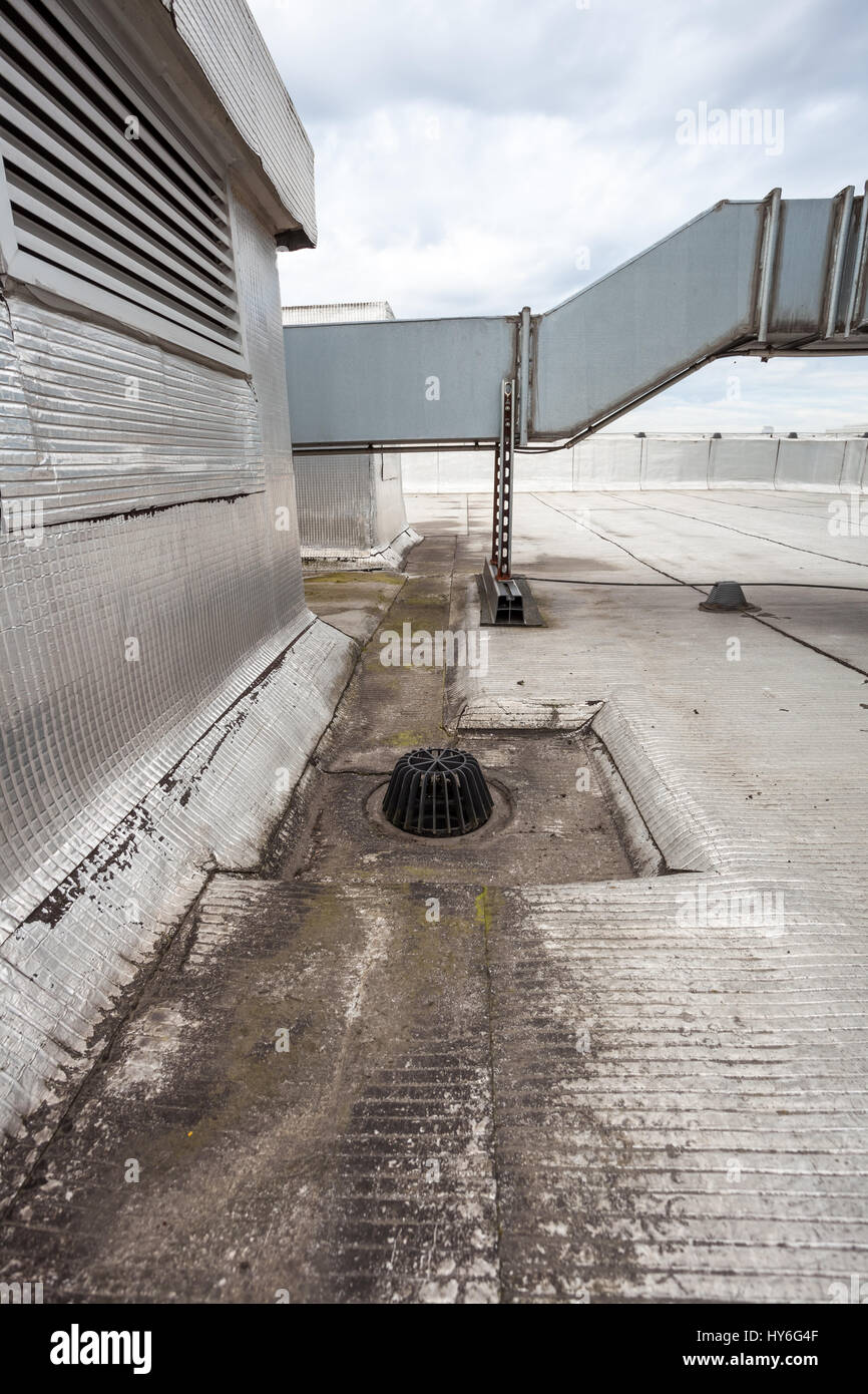 auf ein Flachdach ist Abfluss, um gegen Blätter halten Stockfoto